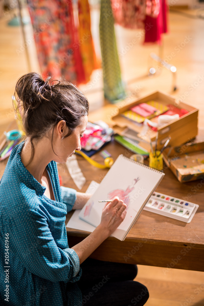 Fashion designer working on a new model, in her studio Fashion designer working on a new model, in her studio