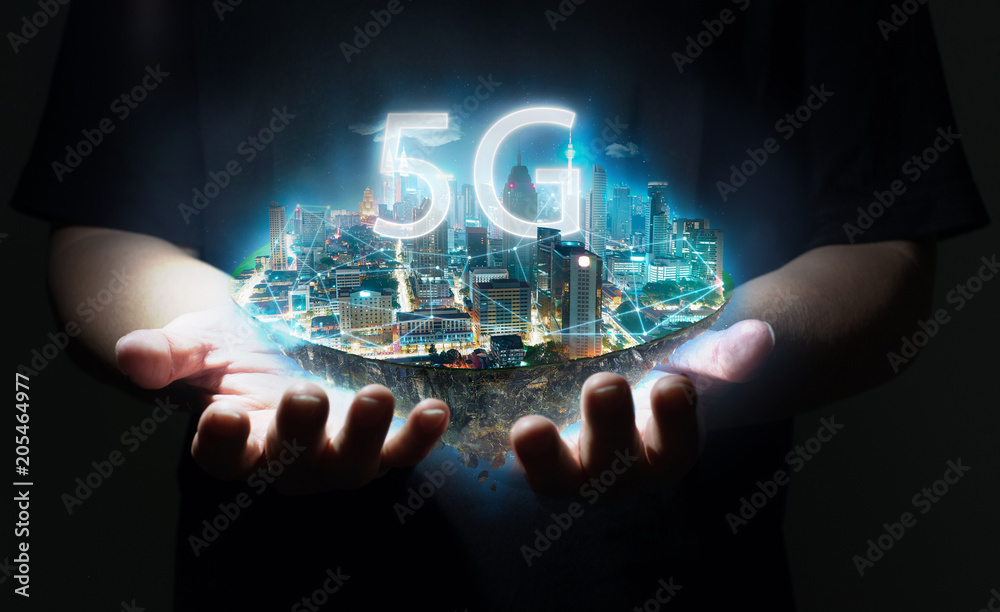 Naklejka premium Unknown hand holding fantasy island floating in the air with 5G network wireless systems , Smart city and communication network concept .