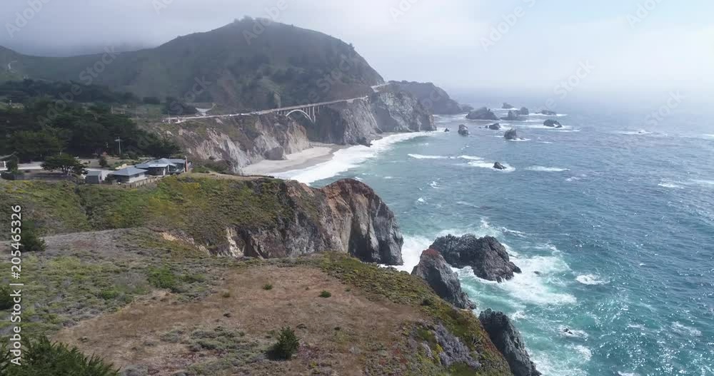 Flight over of rocky coastline. Aerial of Ocean shore, waves crashing cliffs. Time ramp shot.