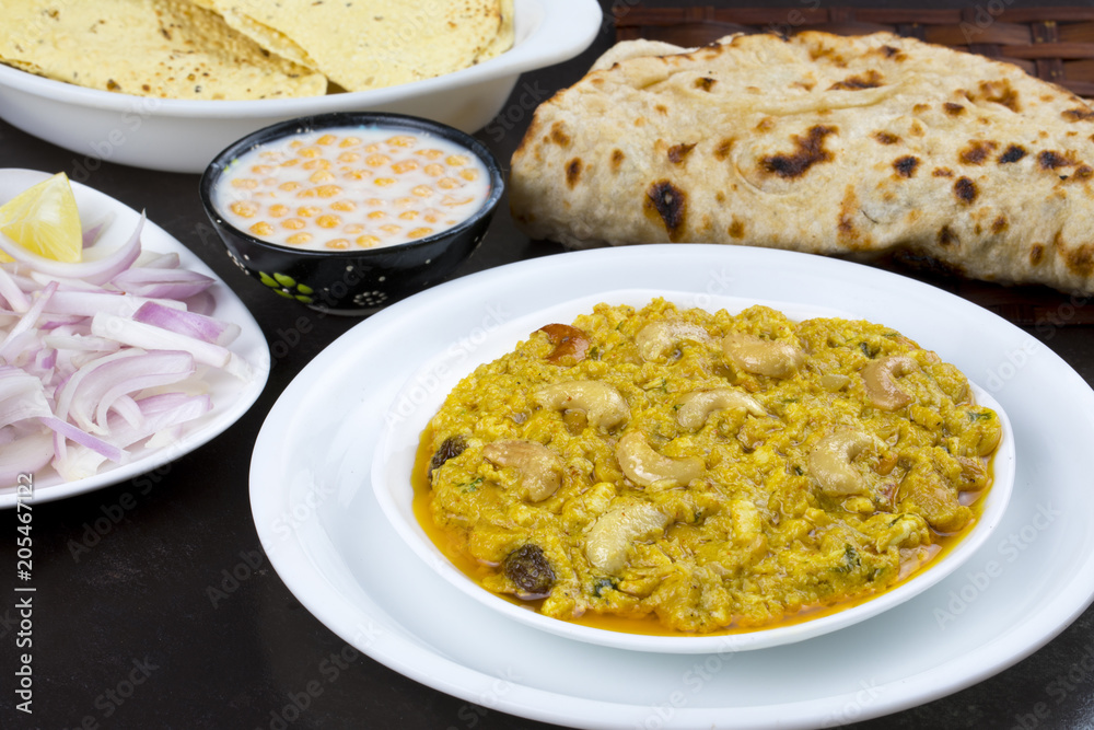 Indian Traditional Vegetarian Cuisine Kaju Curry Also Called Kaju Butter Masala Served with Tandoori Roti, Raita, Salad And Papad Indian Traditional Vegetarian Cuisine Kaju Curry Also Called Kaju Butter Masala Served with Tandoori Roti, Raita, Salad And Papad