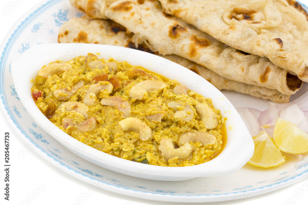 Indian Traditional Vegetarian Cuisine Kaju Curry Also Called Kaju Butter Masala Served With Tandoori Roti And Salad isolated on White Background