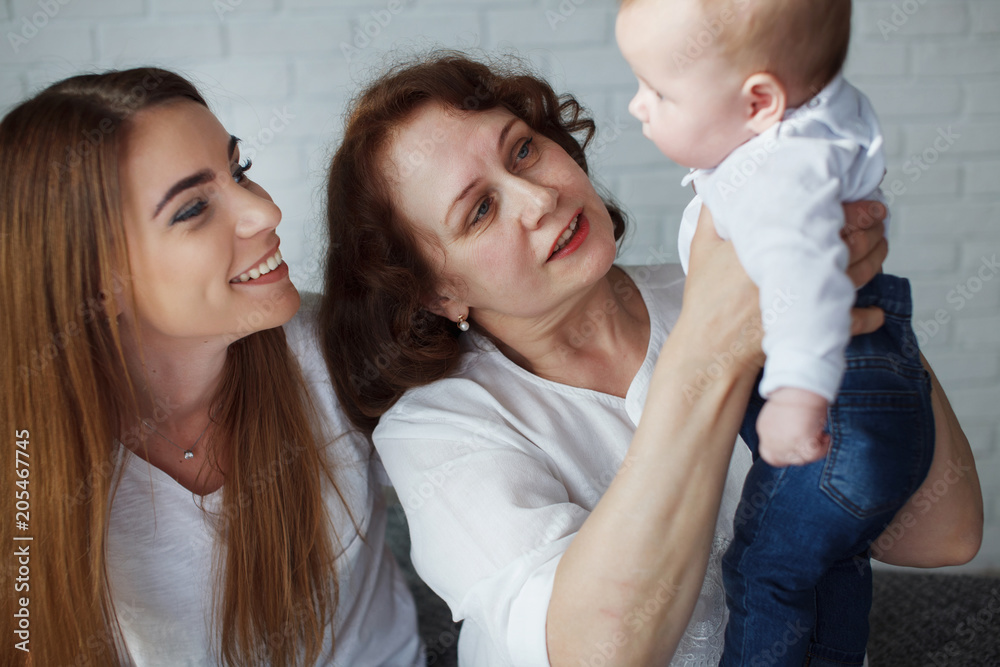Portrait Mother, grandmother and baby are smiling and hugging. The concept of happy generations. Portrait Mother, grandmother and baby are smiling and hugging. The concept of happy generations.