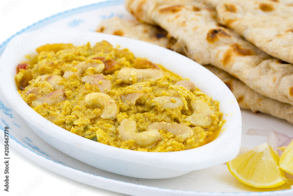 Indian Traditional Vegetarian Cuisine Kaju Curry Also Called Kaju Butter Masala Served With Tandoori Roti And Salad isolated on White Background