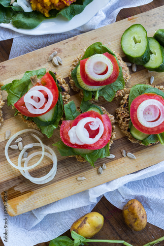 Vegan sandwiches on whole wheat bread with onion rings, tomatoes. fresh salad leaves, and cucumber slices with lemon juice. Vegetables diet for lunch and dinner. Raw vegetarian healthy food