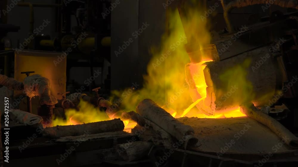 Hot steel pouring at steel plant. In the frame, molten metal is poured through special channels, for the further rolling with a special machine. Modern metallurgical industry