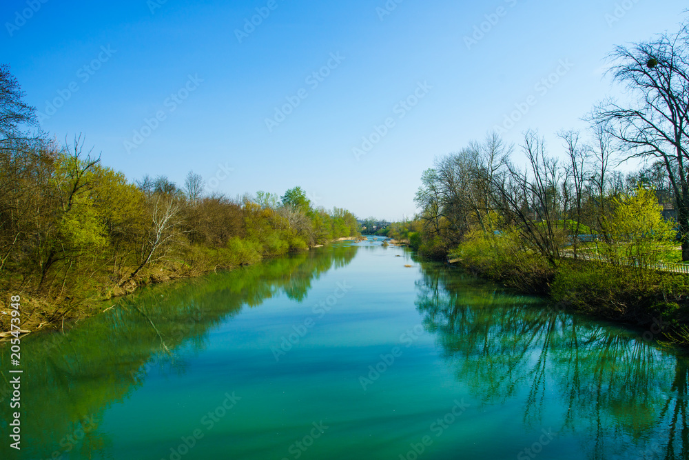 Fototapeta premium Blue river flowing across green forest