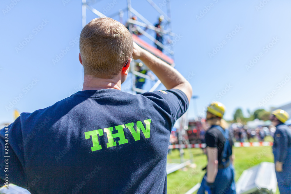Fototapeta premium German technical emergency service sign on a vest from a man. THW, Technisches Hilfswerk means technical emergency service.