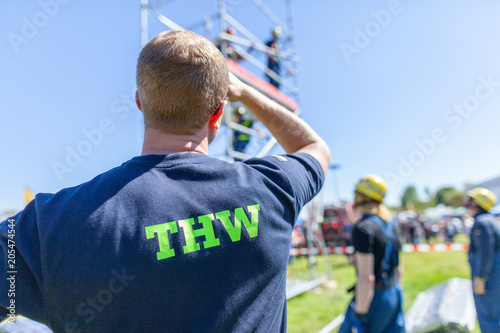 German technical emergency service sign on a vest from a man. THW, Technisches Hilfswerk means technical emergency service. photo