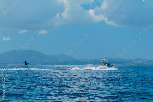 woman glides on water skiing on the waves on the sea, ocean. Healthy lifestyle. Positive human emotions, joy. Family fun at tropical ocean in the day time. Spring and summer holidays.