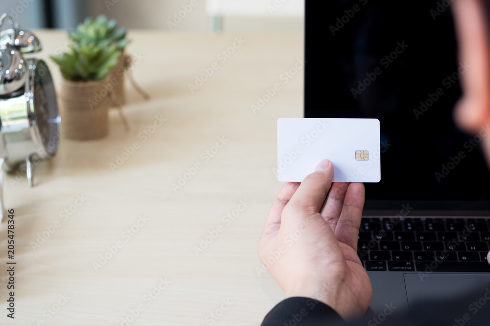 Businessman hand holding credit card and using laptop on desk with document and calculator. Businessman hand holding credit card and using laptop on desk with document and calculator.