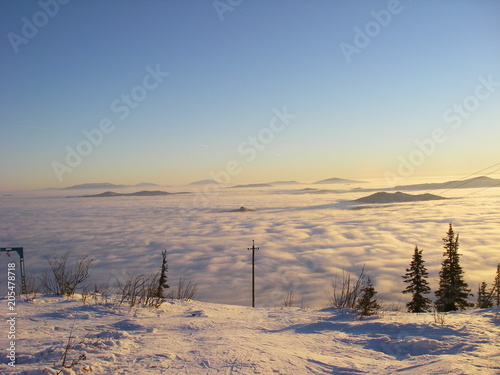 Clouds that covered the mountains in the golden hour in the Siberian mountains