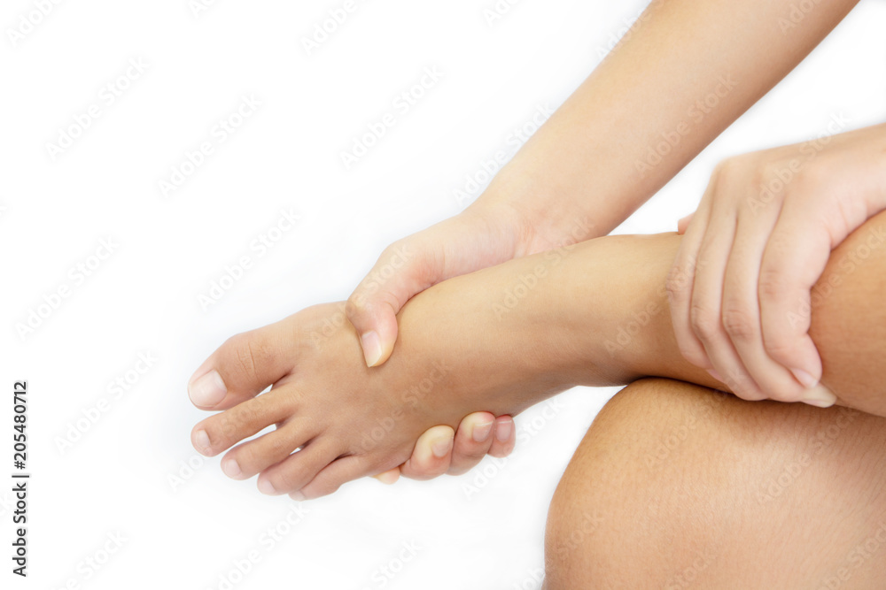 The girl, her ankle pain. She was massaging it To relieve pain. White background The girl, her ankle pain. She was massaging it To relieve pain. White background