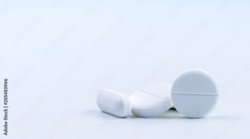 Pile of white round and oblong shape tablet pills isolated on white background. Pharmaceutical industry. Pharmacy or drugstore sign and symbol. Global healthcare concept. Health and pharmacology. Pile of white round and oblong shape tablet pills isolated on white background. Pharmaceutical industry. Pharmacy or drugstore sign and symbol. Global healthcare concept. Health and pharmacology.