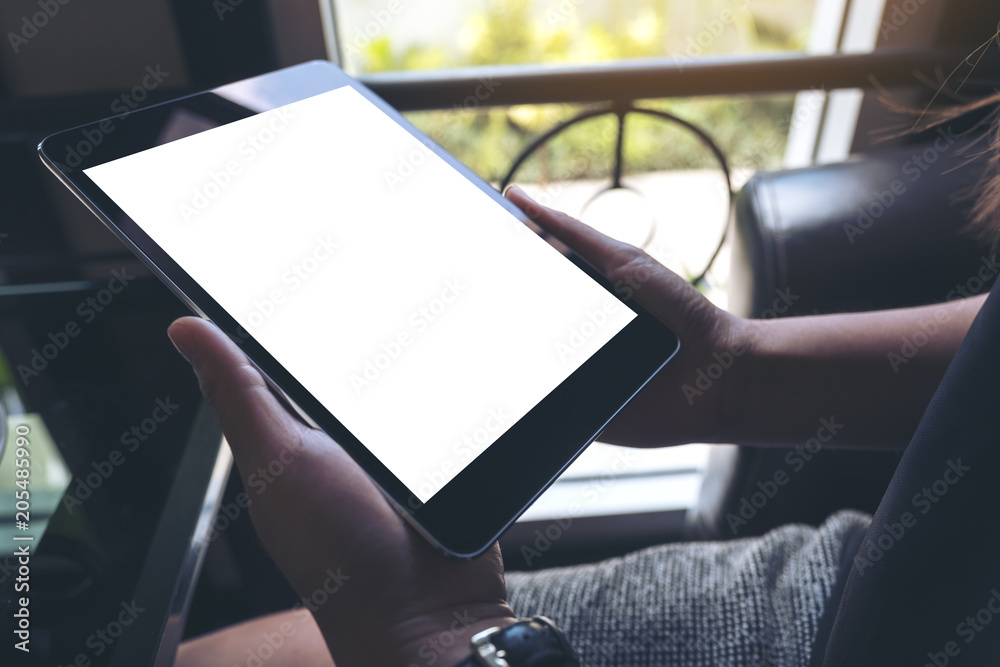Mockup image of hands holding black tablet pc with white blank screen Mockup image of hands holding black tablet pc with white blank screen