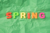 The spring inscription with plastic letters on a green background
