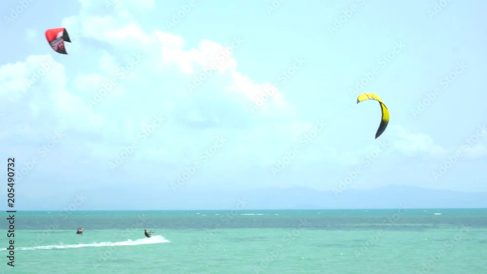 Young man kitesurfing in tropical blue ocean Young man kitesurfing in tropical blue ocean