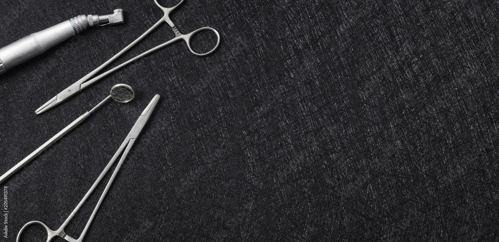 Professional dental tools layed on dark background. Copy space for text. Professional dental tools layed on dark background. Copy space for text.