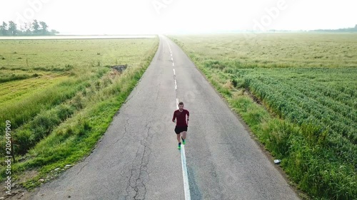 Drone view of a man running in the countryside
