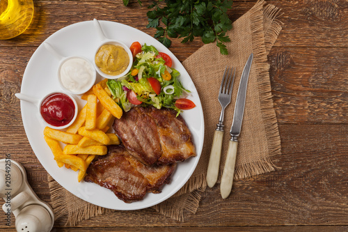 Fototapeta Naklejka Na Ścianę i Meble -  Grilled pork neck served with French fries and salad.