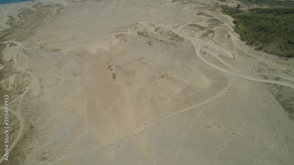 Aerial view of beautiful lonely beach and Paoay sand dune. Philippines, Luzon. Sand dunes near to the sea with sky. Ilocos Norte. Aerial view of beautiful lonely beach and Paoay sand dune. Philippines, Luzon. Sand dunes near to the sea with sky. Ilocos Norte.