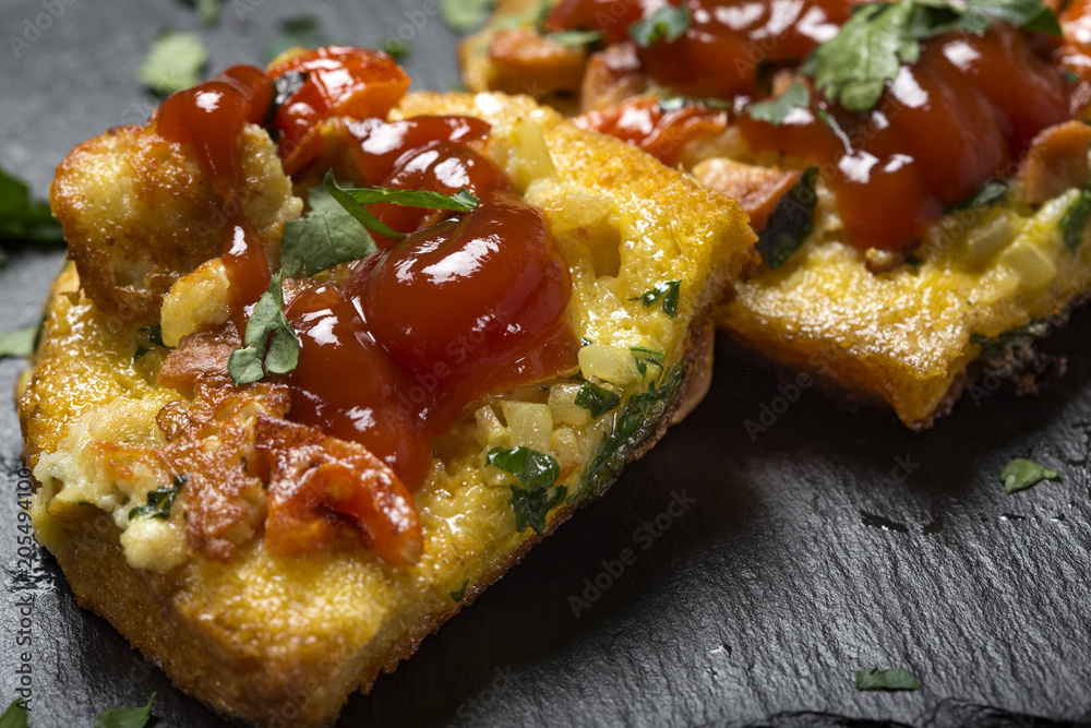 Delicious homemade fried egg in toast for breakfast with frankfurters, onion, cheese and parsley Delicious homemade fried egg in toast for breakfast with frankfurters, onion, cheese and parsley