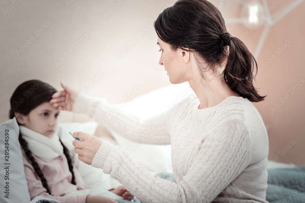 Will treat you. Sick girl pressing lips and looking at her mom while having headache Will treat you. Sick girl pressing lips and looking at her mom while having headache