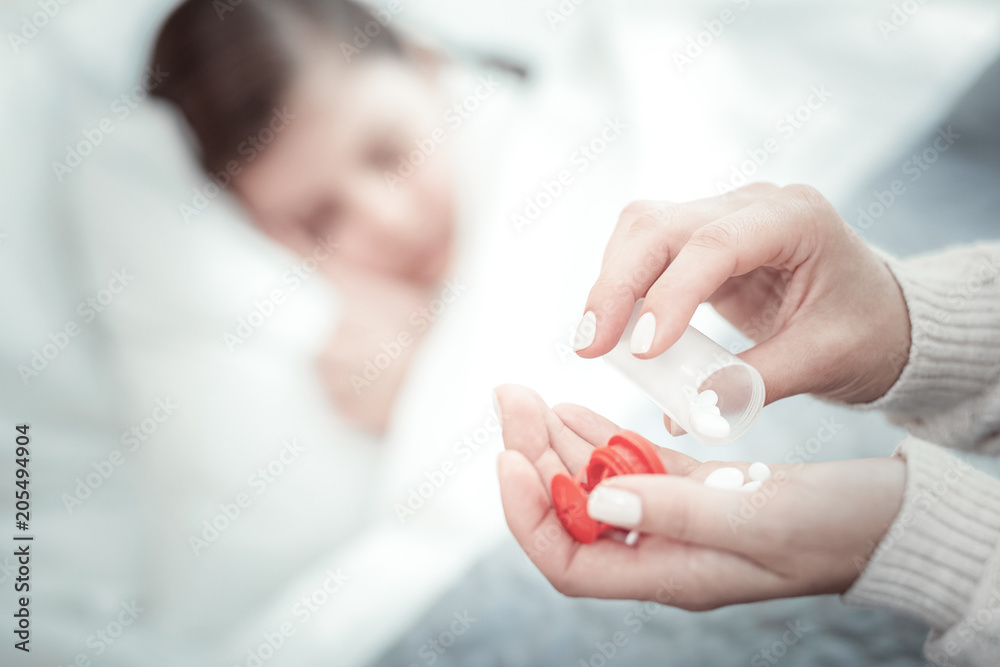 Useful pills. Silhouette of ill girl that having headache and keeping eyes closed while sleeping Useful pills. Silhouette of ill girl that having headache and keeping eyes closed while sleeping