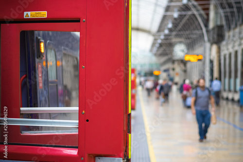 Select focus, train door with blurry passengers in the background at London Paddington rail station