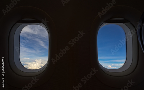 Airplane window, cloudscape seen through an airplane window from the passenger seat.