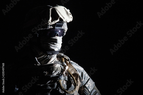 Tablou canvas Close up portrait of modern infantry soldier, active army fighter, military mercenary in helmet, face hidden with balaclava and glasses high contrast, cropped on black background
