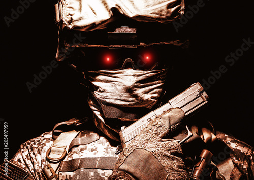Fotografija Special operations forces soldier in combat helmet with terrible burning red eyes posing with sidearm service pistol in hand