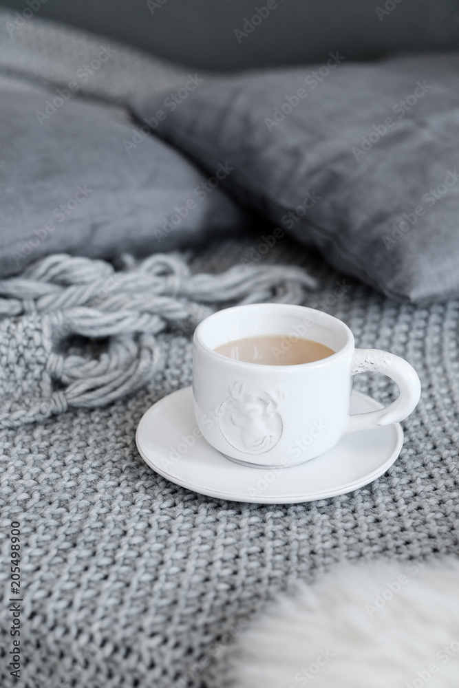 A cup of coffee on a gray plaid A cup of coffee on a gray plaid
