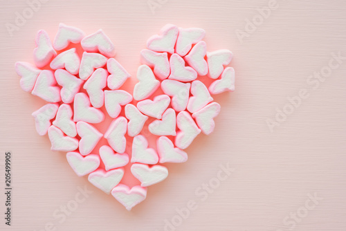 Fototapeta Naklejka Na Ścianę i Meble -  Fluffy pink heart marshmallow heart shape on pink background from top view