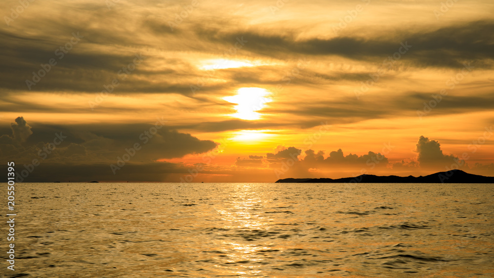 Sunset with sunlight or sunrays or sunbeams over sea or ocean with orange or golden light tone. Sunset with sunlight or sunrays or sunbeams over sea or ocean with orange or golden light tone.