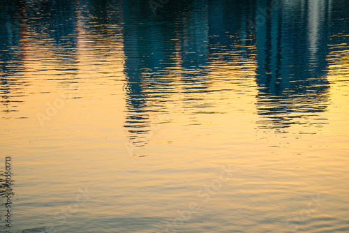 Water surface cityscape reflection with golden sunset