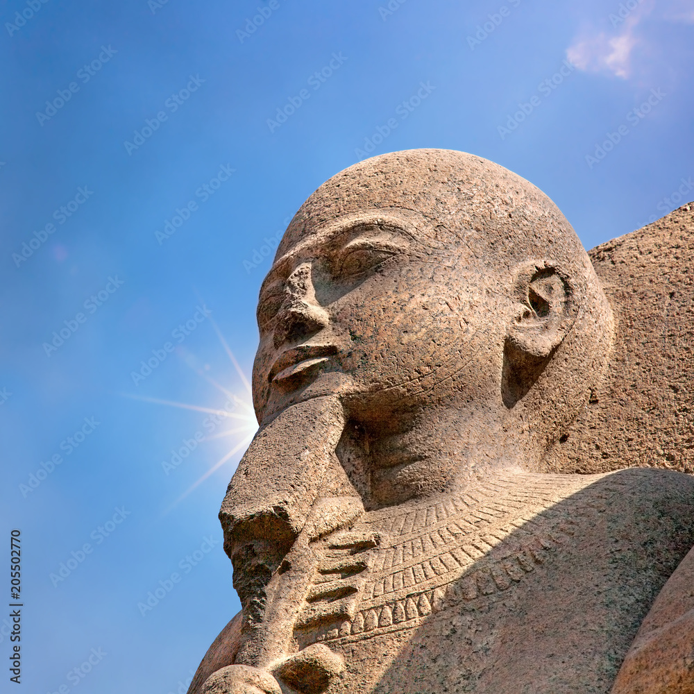 Ancient Egyptian statue in Cairo, Egypt. Blue sky and sun flare background. Ancient Egyptian statue in Cairo, Egypt. Blue sky and sun flare background.