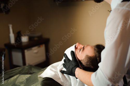 Master cuts hair and beard of men in the barbershop