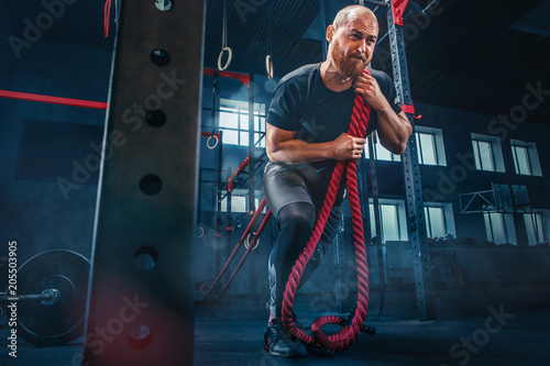Men with battle rope battle...