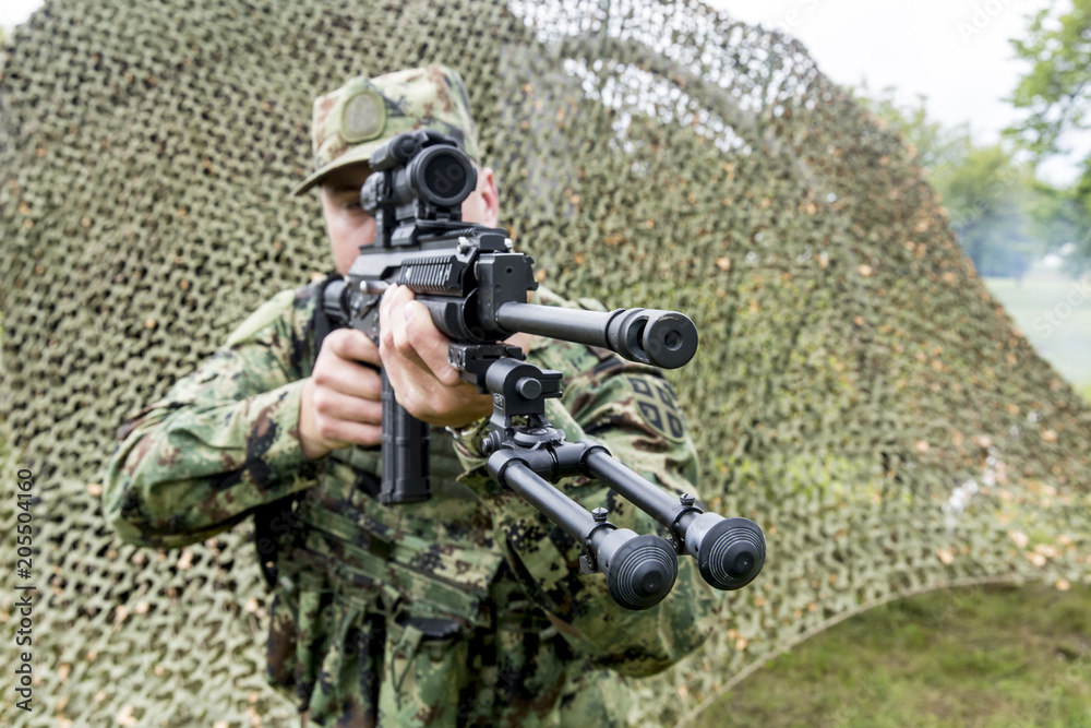 a soldier with an automatic rifle in his hand and ready to shoot