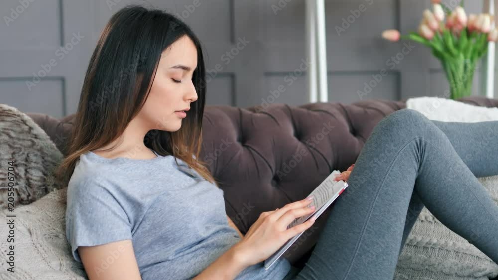 Young woman using digital tablet on sofa Young woman using digital tablet on sofa