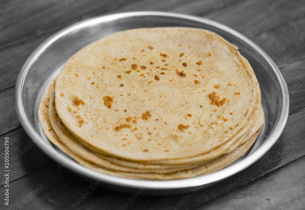 Indian Cuisine Roti Also Called Chapati, Flatbread, Naan or Nan Bread on Wooden Background Indian Cuisine Roti Also Called Chapati, Flatbread, Naan or Nan Bread on Wooden Background