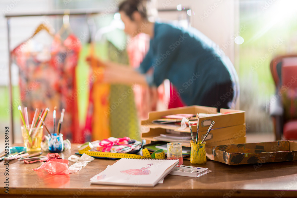 Fashion designer working on a new model, in her studio Fashion designer working on a new model, in her studio