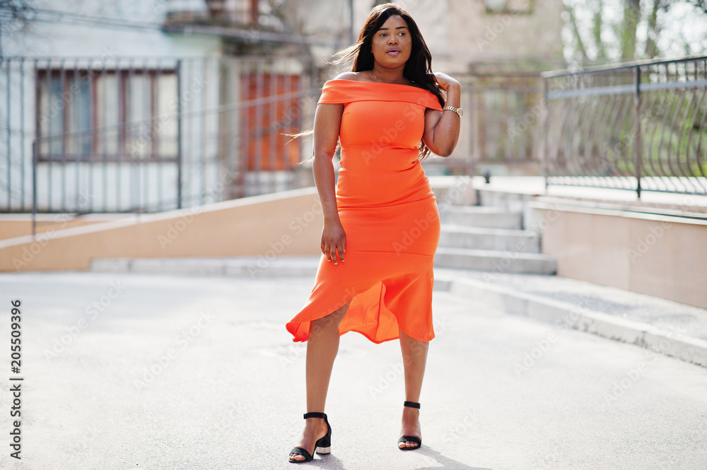 African american woman model xxl in orange dress. African american woman model xxl in orange dress.