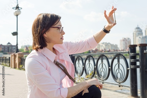 Woman in the street holds key in her hand.