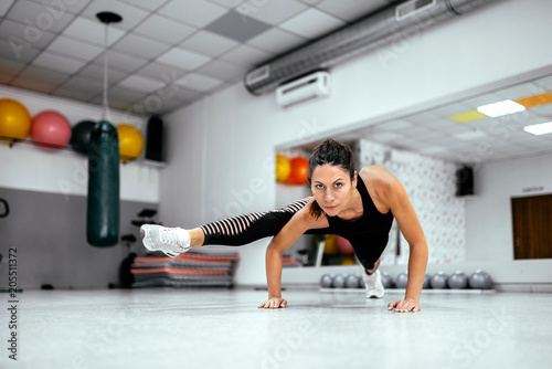 Core strength and stability workout. Young woman exercising at the gym.