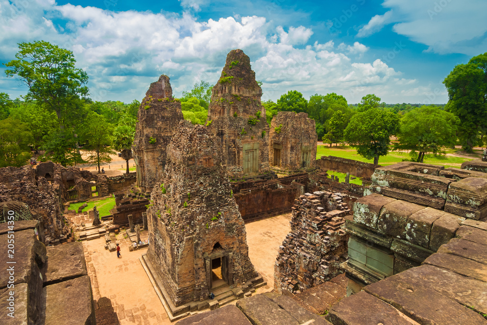 A wonderful view of the east side of Cambodia's ancient Pre Rup temple with its reddish library and tower ruins taken from the top of the final squared pyramid in the centre.