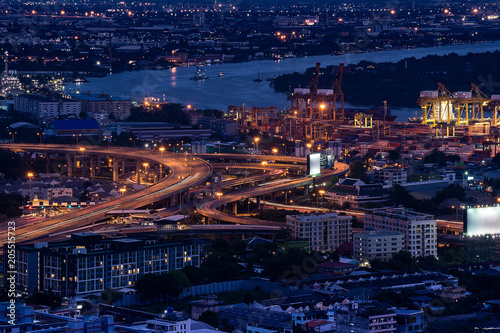 Bangkok cityscape from skybar with port, expressway and light tail under twilight in the evening.