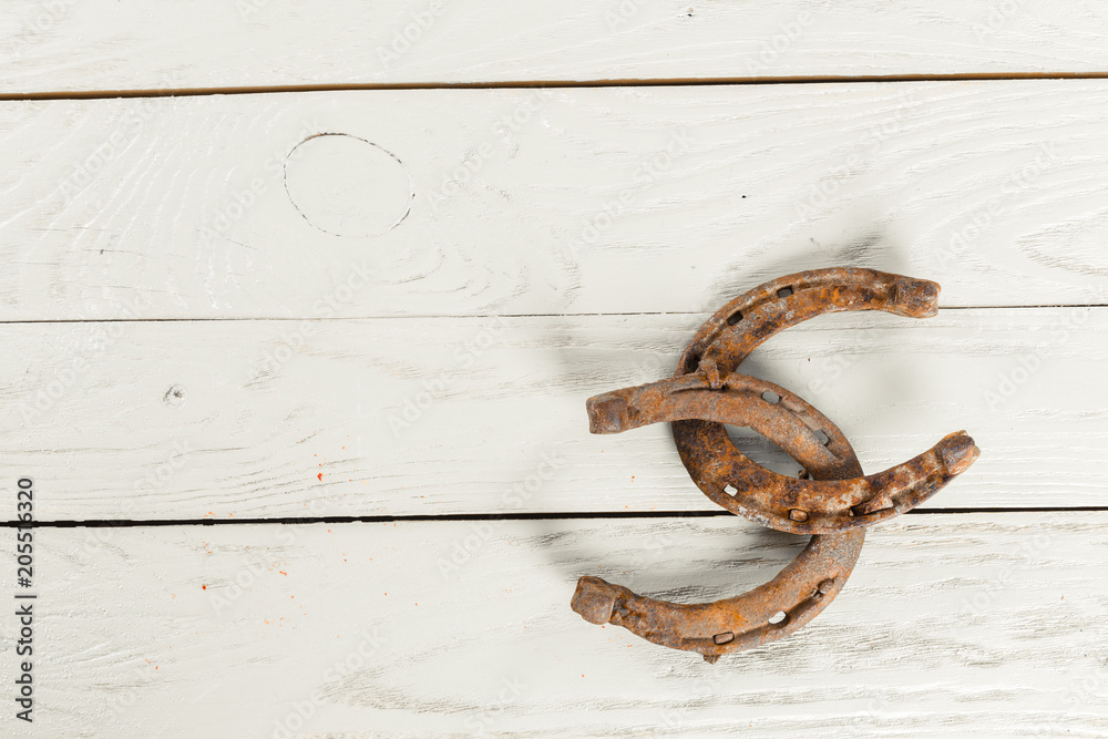 old rusty horseshoes on wooden board old rusty horseshoes on wooden board