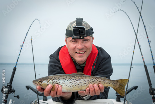 Angler with small trout fishing trophy