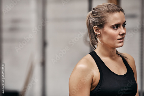 Fit young woman looking focused while standing in a gym
